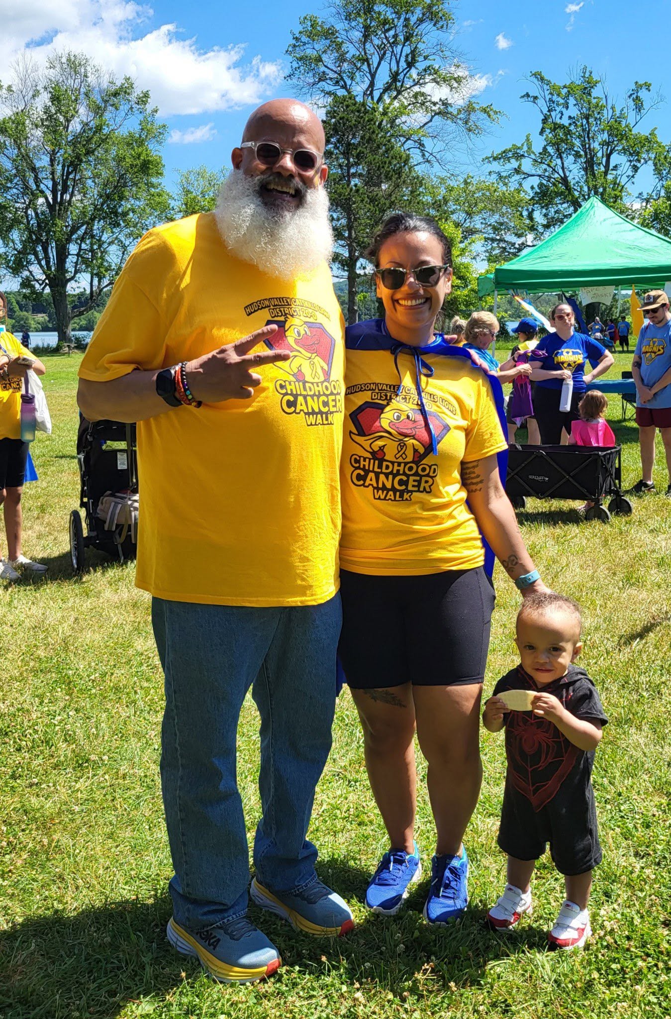 Family posing in Childhood Cancer Walk shirts