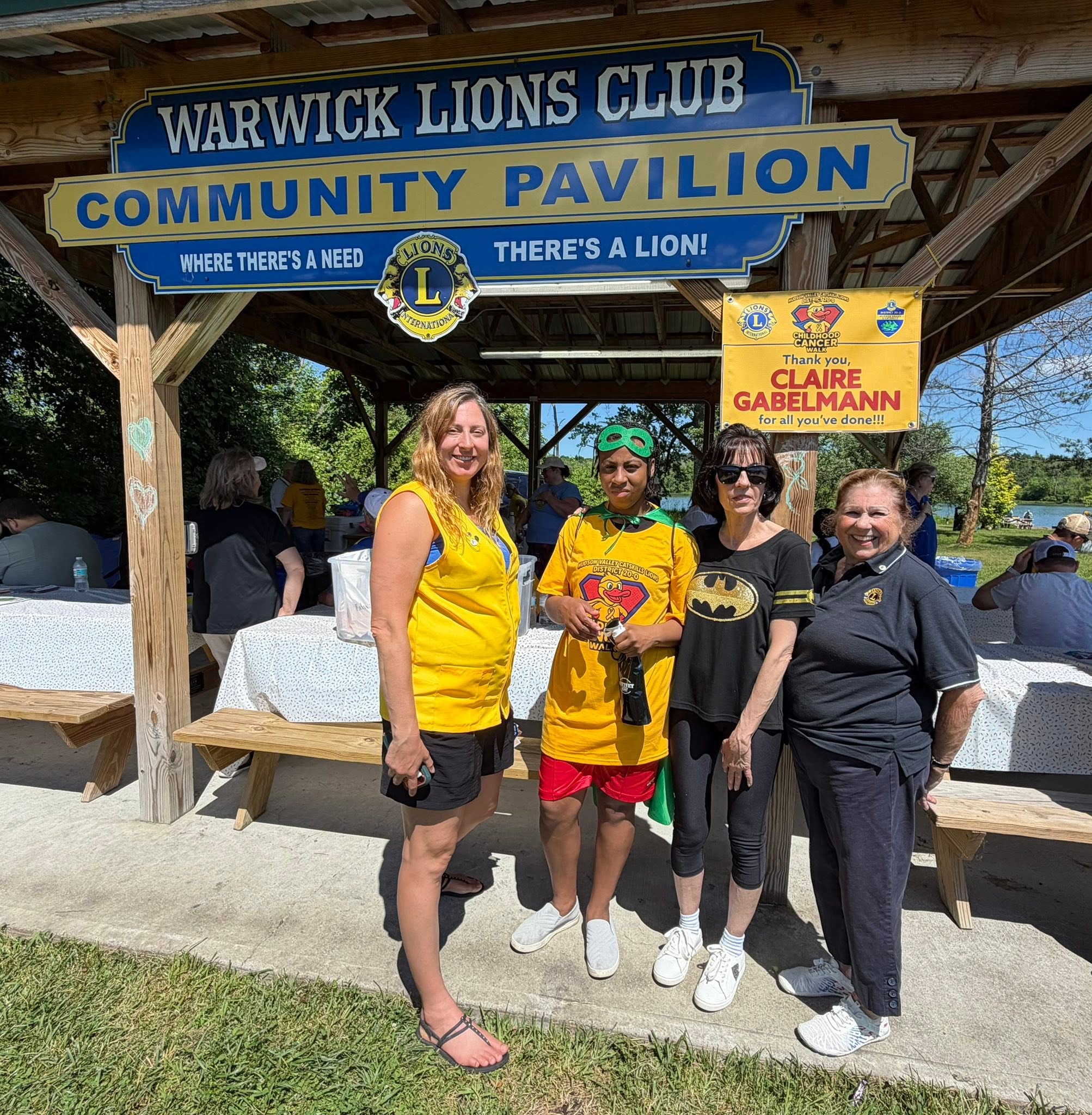 Four volunteers under the Community Pavilion sign