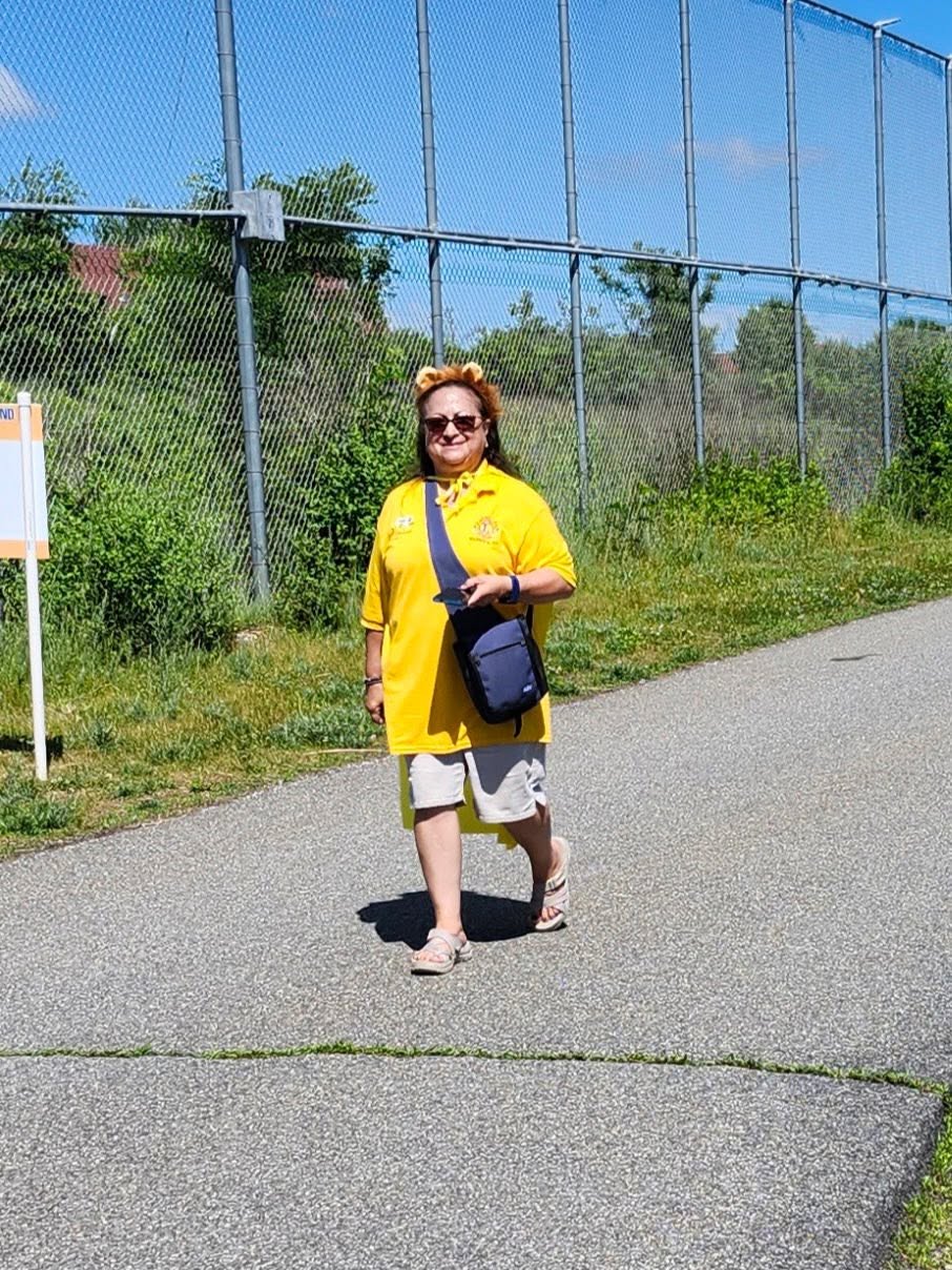 Walker in a yellow shirt and lion ears on the path