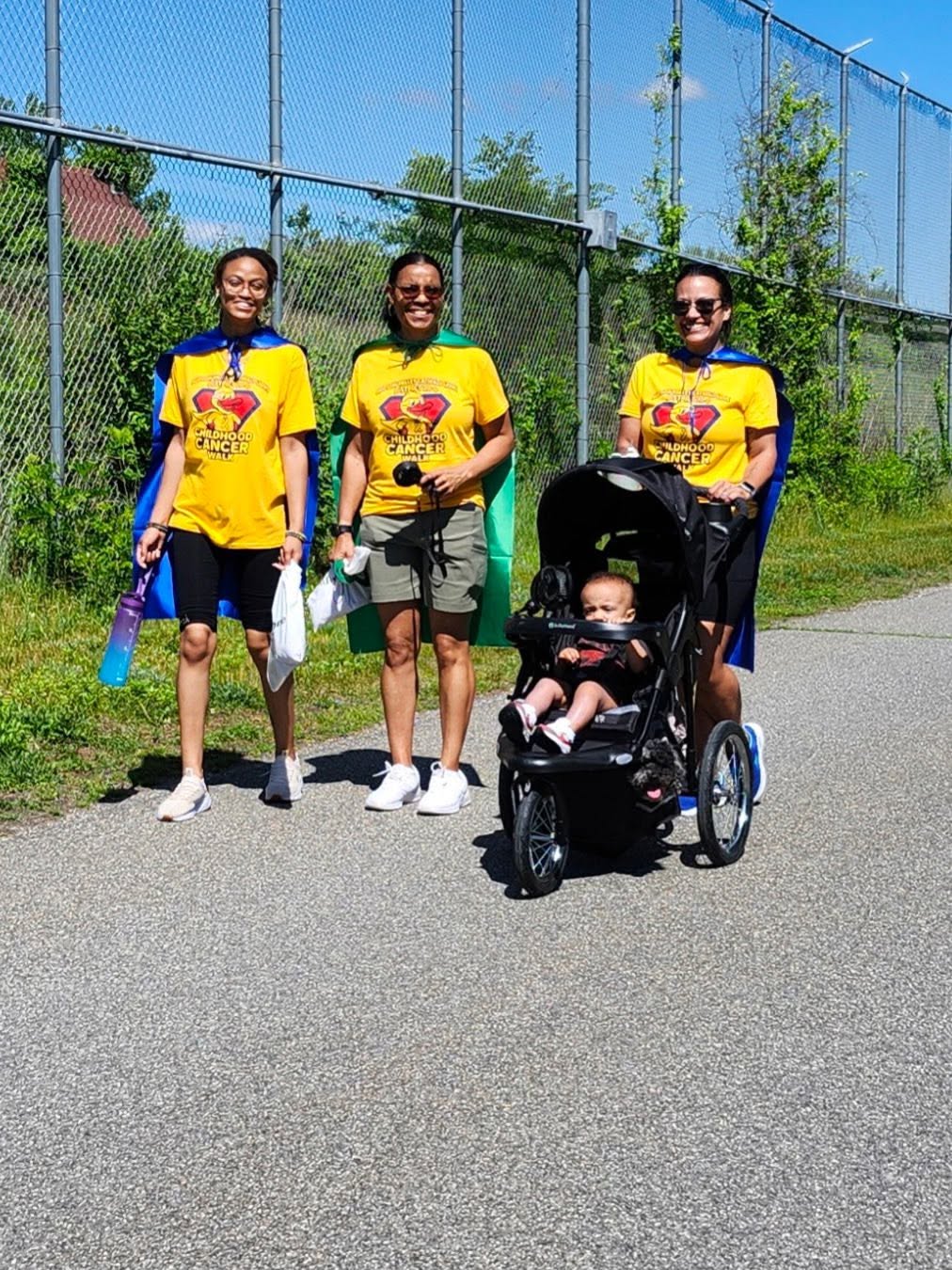 Three walkers with a baby stroller on the walk path
